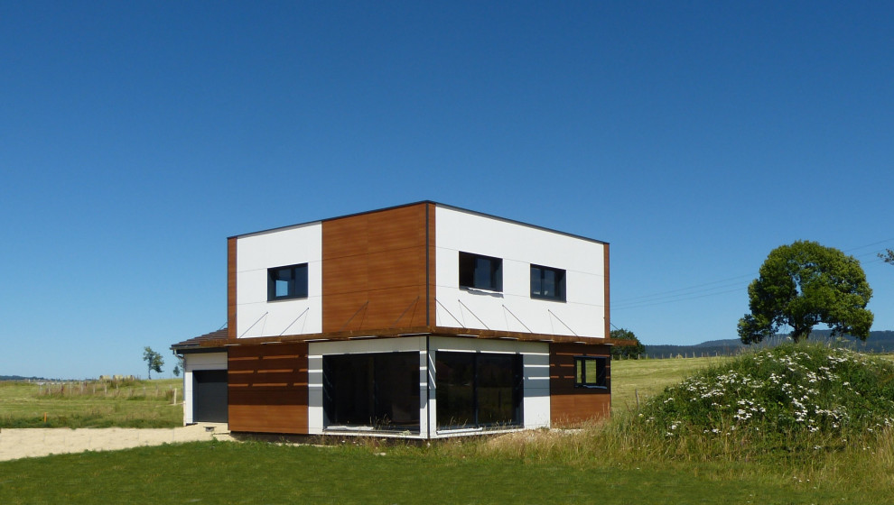 Пример оригинального дизайна: двухэтажный, деревянный, белый частный загородный дом среднего размера в современном стиле с плоской крышей, зеленой крышей, коричневой крышей и отделкой доской с нащельником