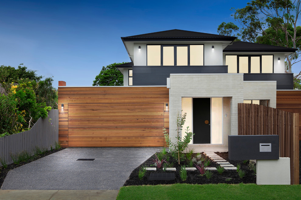 Large contemporary two-storey brick beige townhouse exterior in Melbourne with a metal roof.
