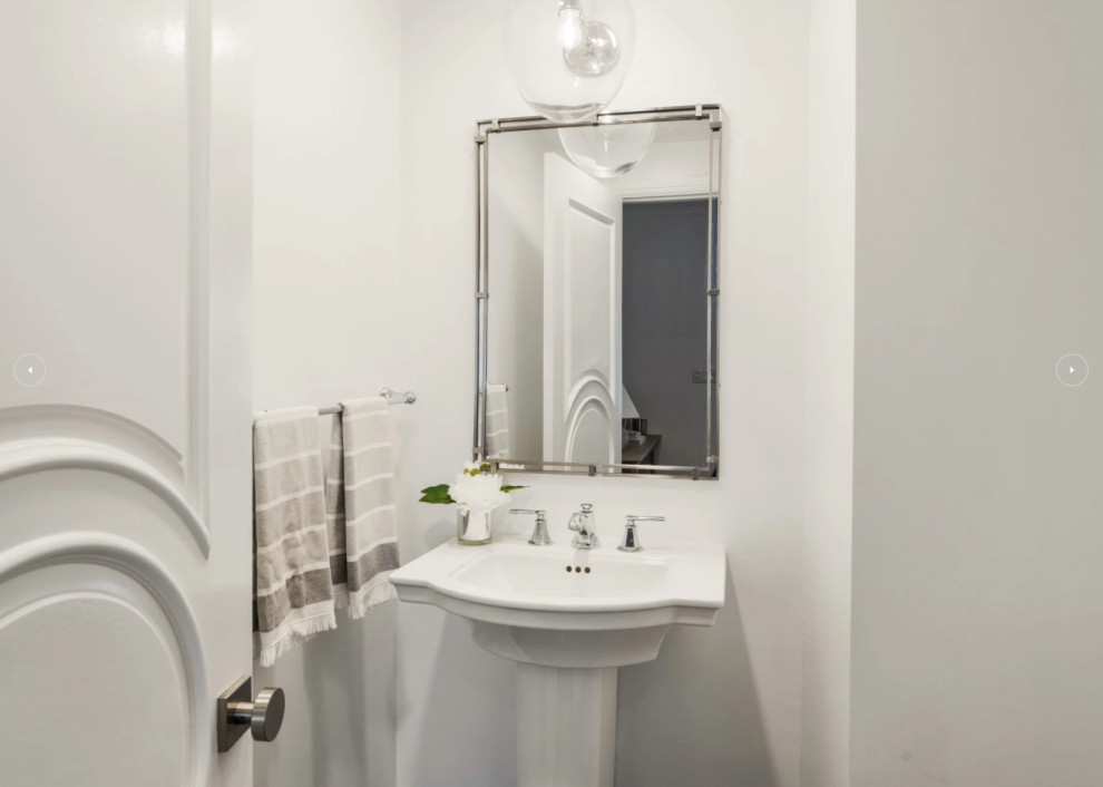 Пример оригинального дизайна: туалет среднего размера в стиле неоклассика (современная классика) с унитазом-моноблоком, белыми стенами, темным паркетным полом, раковиной с пьедесталом, коричневым полом и напольной тумбой