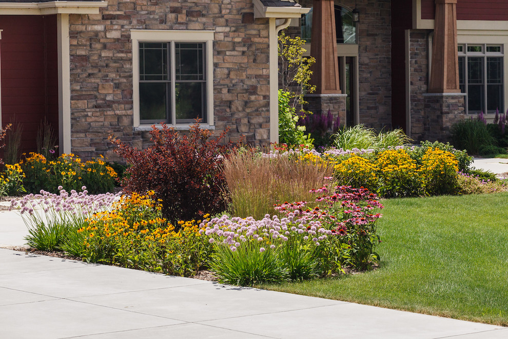 Inspiration for a large traditional front yard full sun driveway for summer in Milwaukee with a garden path and natural stone pavers.