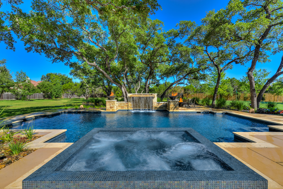 This is an example of a large mediterranean backyard custom-shaped pool in Austin with a hot tub and concrete pavers.