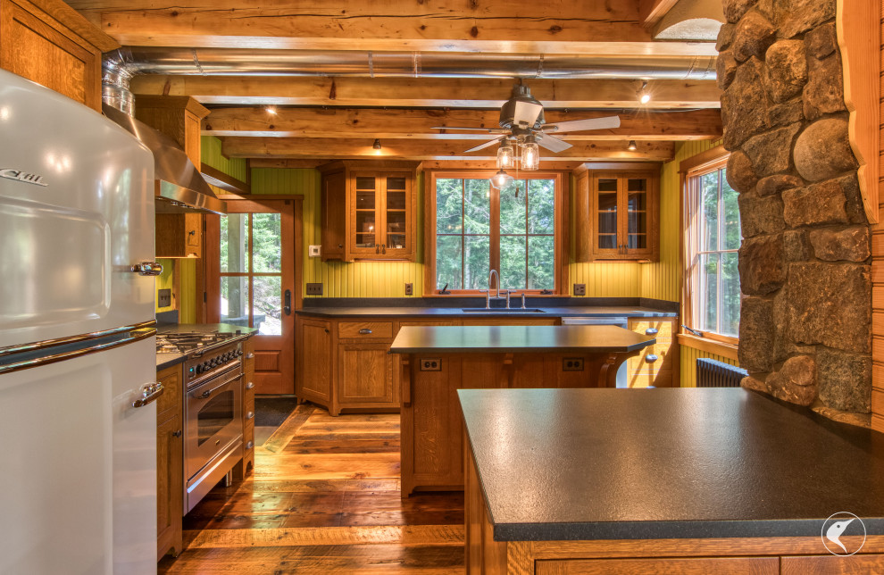 Inspiration for a rustic medium tone wood floor and exposed beam kitchen remodel with an undermount sink, shaker cabinets, granite countertops, black backsplash, granite backsplash, stainless steel appliances and black countertops