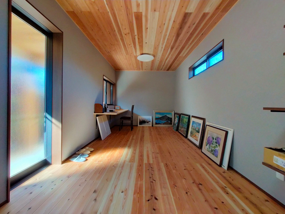 На фото: маленький кабинет с серыми стенами, светлым паркетным полом, встроенным рабочим столом, бежевым полом, деревянным потолком и обоями на стенах для на участке и в саду с