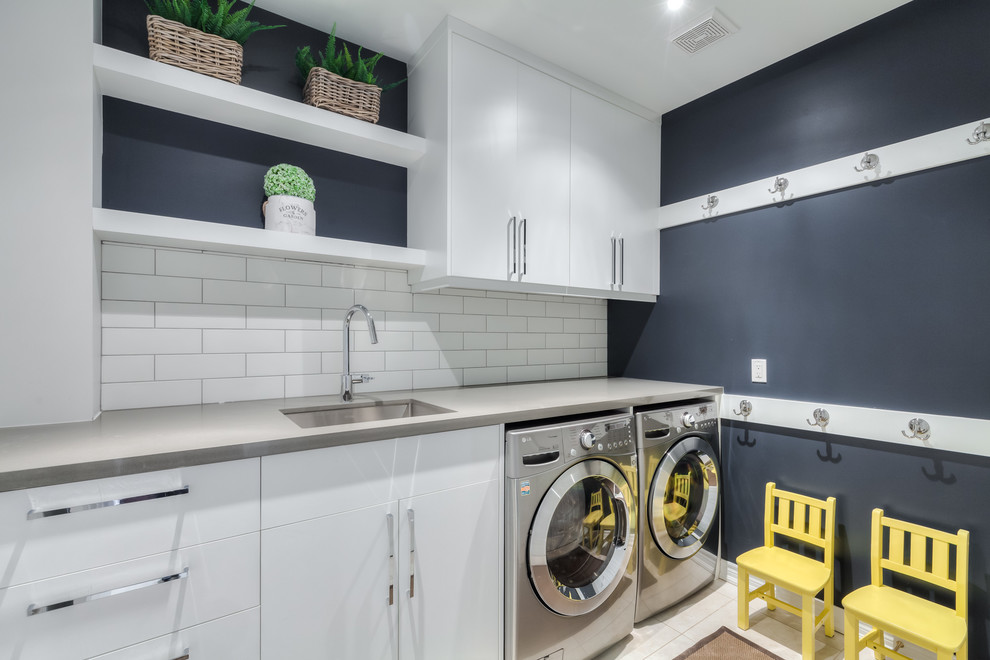 Small transitional single-wall utility room in Toronto with an undermount sink, flat-panel cabinets, white cabinets, quartz benchtops, blue walls, ceramic floors, a side-by-side washer and dryer and beige floor.