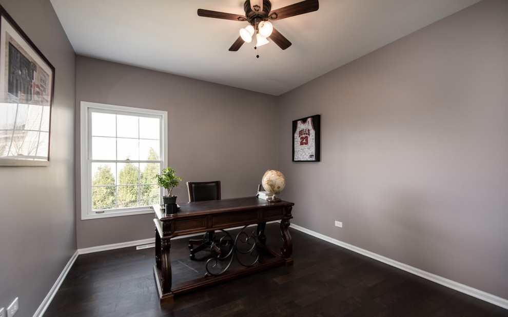 Large transitional study room in Chicago with grey walls, dark hardwood floors, no fireplace, a freestanding desk and grey floor.