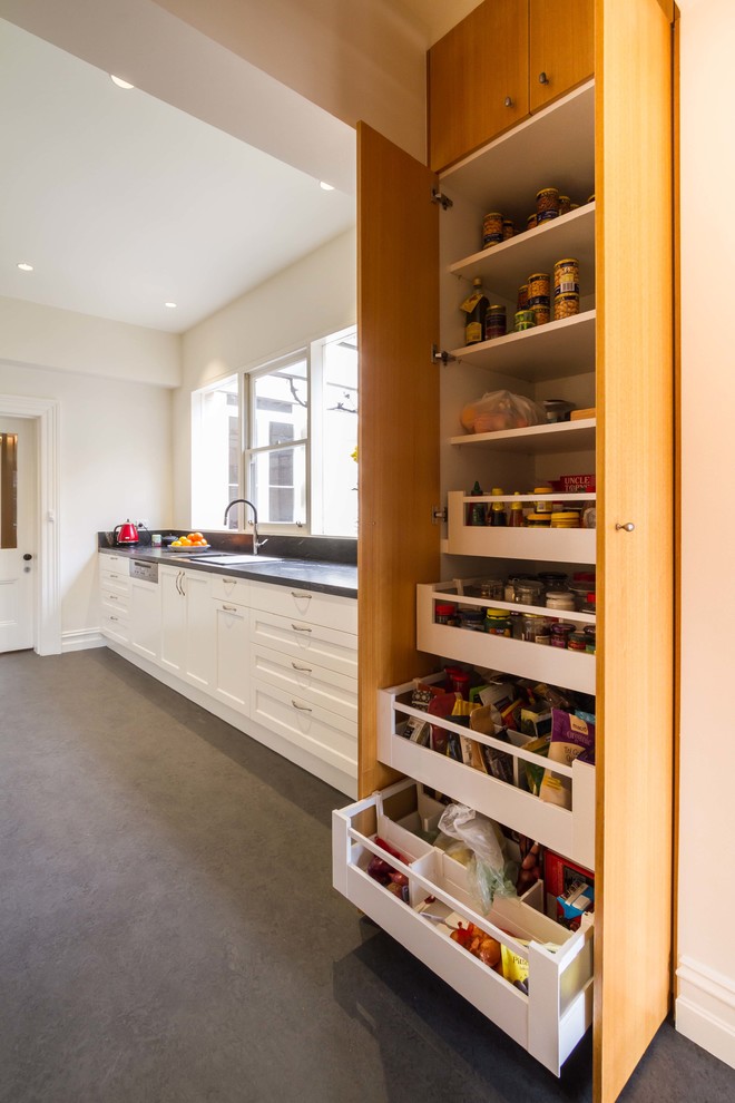 Photo of a mid-sized transitional galley separate kitchen in Melbourne with a drop-in sink, shaker cabinets, white cabinets, granite benchtops and no island.