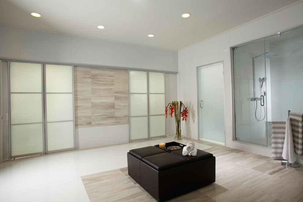 Photo of an expansive contemporary master bathroom in Miami with flat-panel cabinets, medium wood cabinets, a drop-in tub, a double shower, a one-piece toilet, white tile, stone slab, multi-coloured walls, marble floors, a trough sink and glass benchtops.