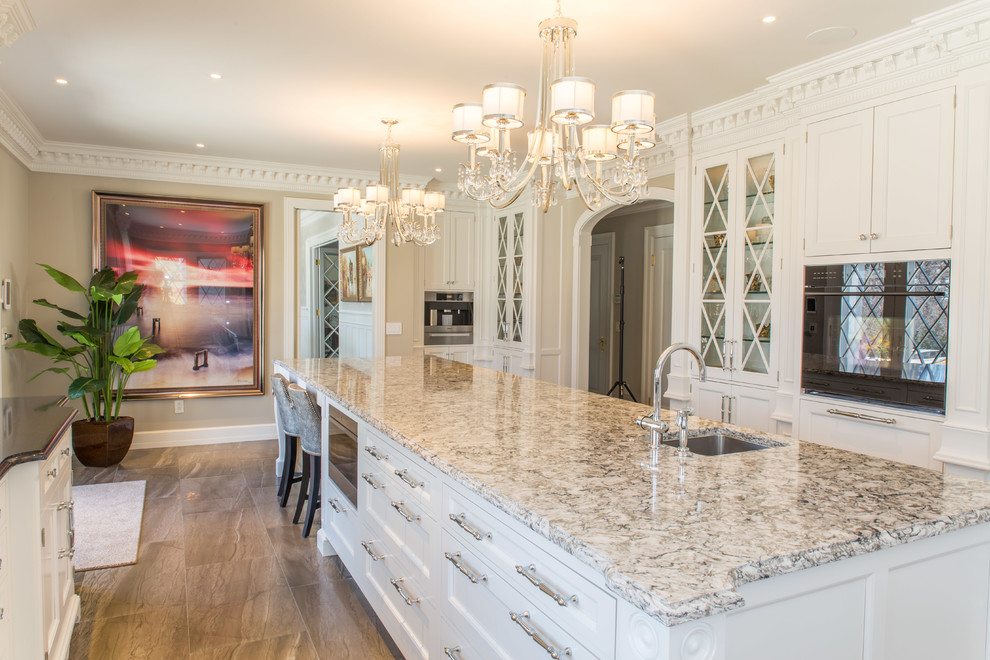 Large traditional galley eat-in kitchen in New York with an undermount sink, beaded inset cabinets, white cabinets, quartzite benchtops, white splashback, stone tile splashback, panelled appliances, porcelain floors and with island.