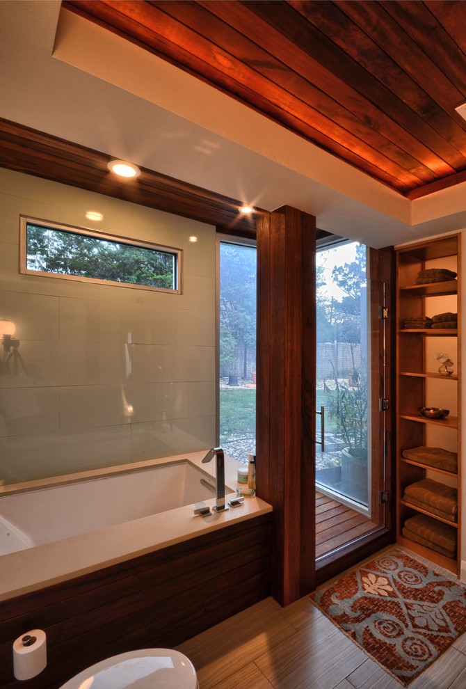 Photo of a mid-sized contemporary master bathroom in Austin with flat-panel cabinets, dark wood cabinets, green tile, glass sheet wall, white walls and light hardwood floors.
