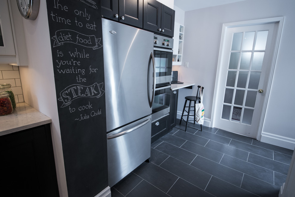 Example of a transitional galley home design design in Ottawa with recessed-panel cabinets, black cabinets, quartzite countertops, white backsplash, stainless steel appliances and no island