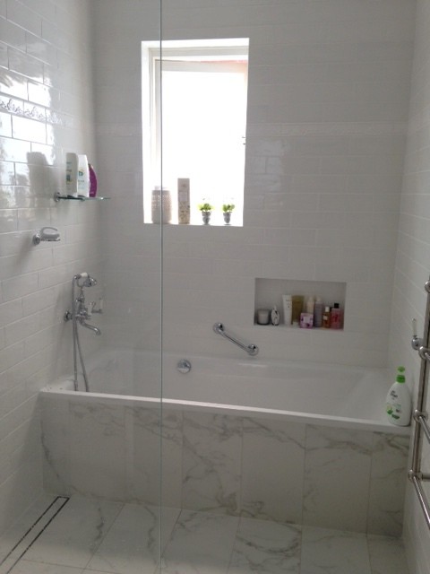 Photo of a transitional bathroom in Sydney with medium wood cabinets, beige tile and glass tile.