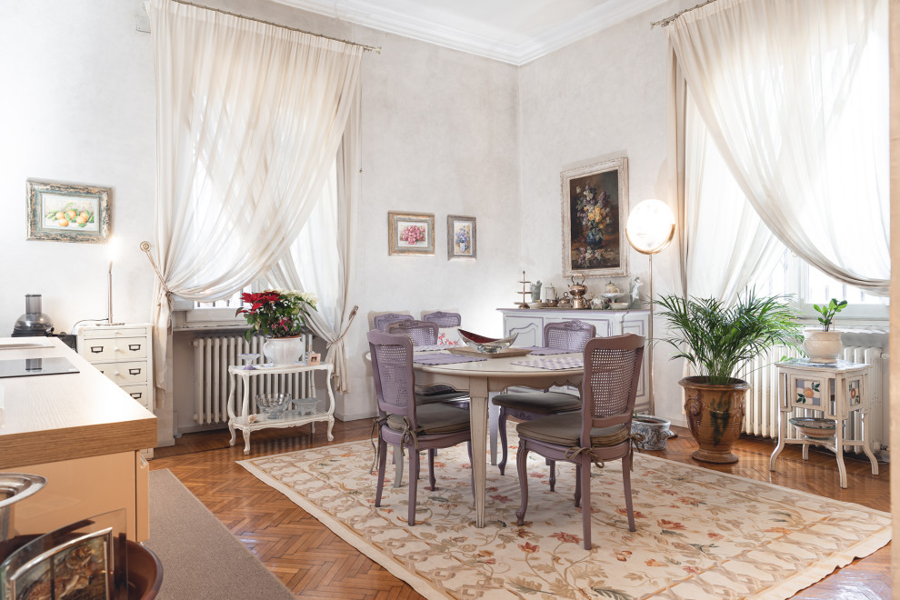 Ispirazione per una sala da pranzo aperta verso la cucina classica di medie dimensioni con pareti bianche, parquet chiaro e pavimento marrone