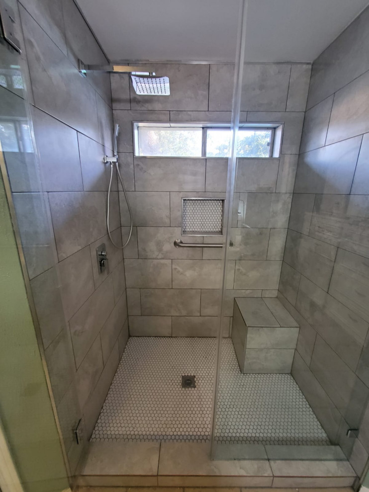 Inspiration pour une salle de bain grise et blanche minimaliste de taille moyenne avec un carrelage gris, des carreaux de porcelaine, un mur gris, une cabine de douche à porte battante, un banc de douche et un plafond voûté.