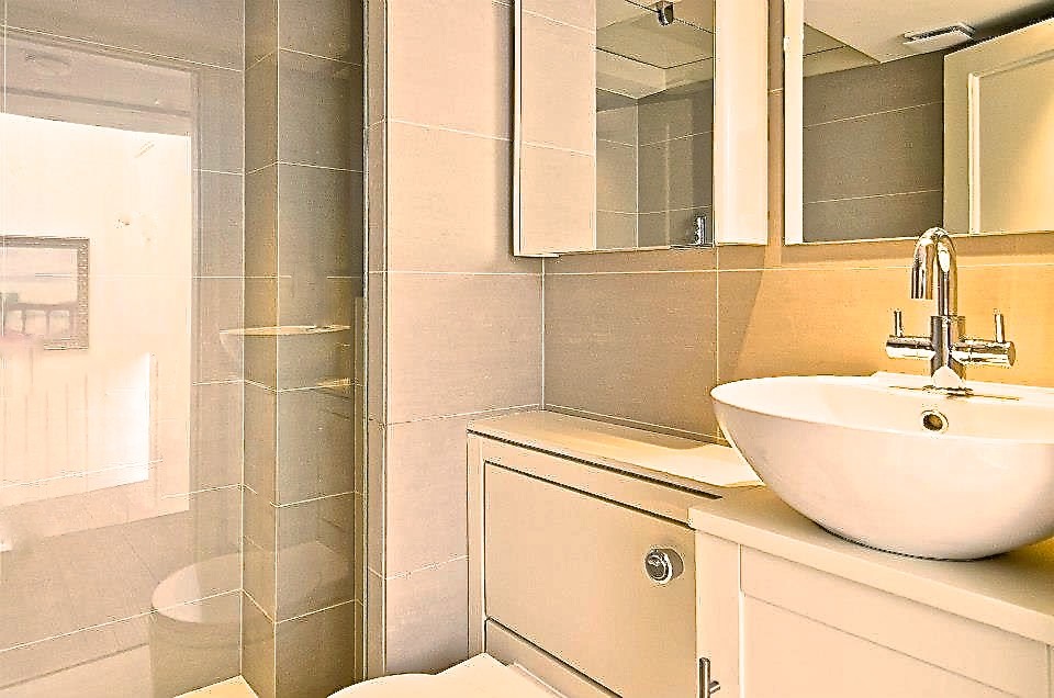 Small contemporary 3/4 bathroom in San Francisco with an open shower, a wall-mount toilet, beige tile, ceramic tile, limestone floors and a console sink.