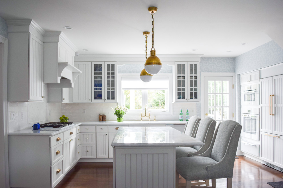 Inspiration for a mid-sized traditional l-shaped eat-in kitchen in New York with an undermount sink, recessed-panel cabinets, white cabinets, quartzite benchtops, white splashback, subway tile splashback, stainless steel appliances, dark hardwood floors and with island.