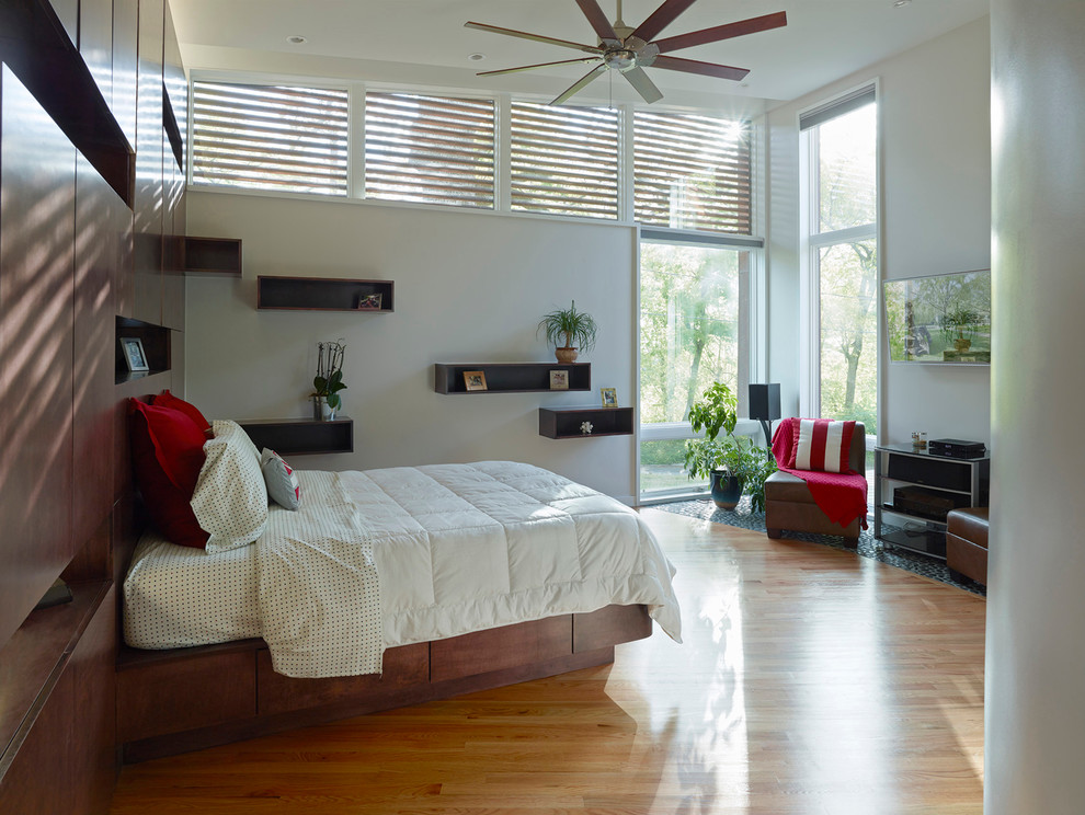 This is an example of a mid-sized modern master bedroom in Other with white walls and light hardwood floors.