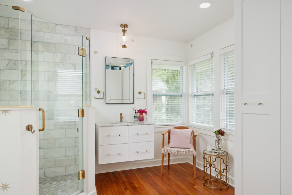 This is an example of a mid-sized traditional master bathroom in Tampa with shaker cabinets, white cabinets, a corner shower, a two-piece toilet, yellow tile, porcelain tile, white walls, medium hardwood floors, an undermount sink, quartzite benchtops, brown floor, a hinged shower door and grey benchtops.