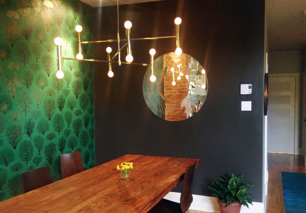 Immagine di una sala da pranzo aperta verso la cucina bohémian di medie dimensioni con pareti verdi, pavimento in legno massello medio, pavimento marrone e carta da parati