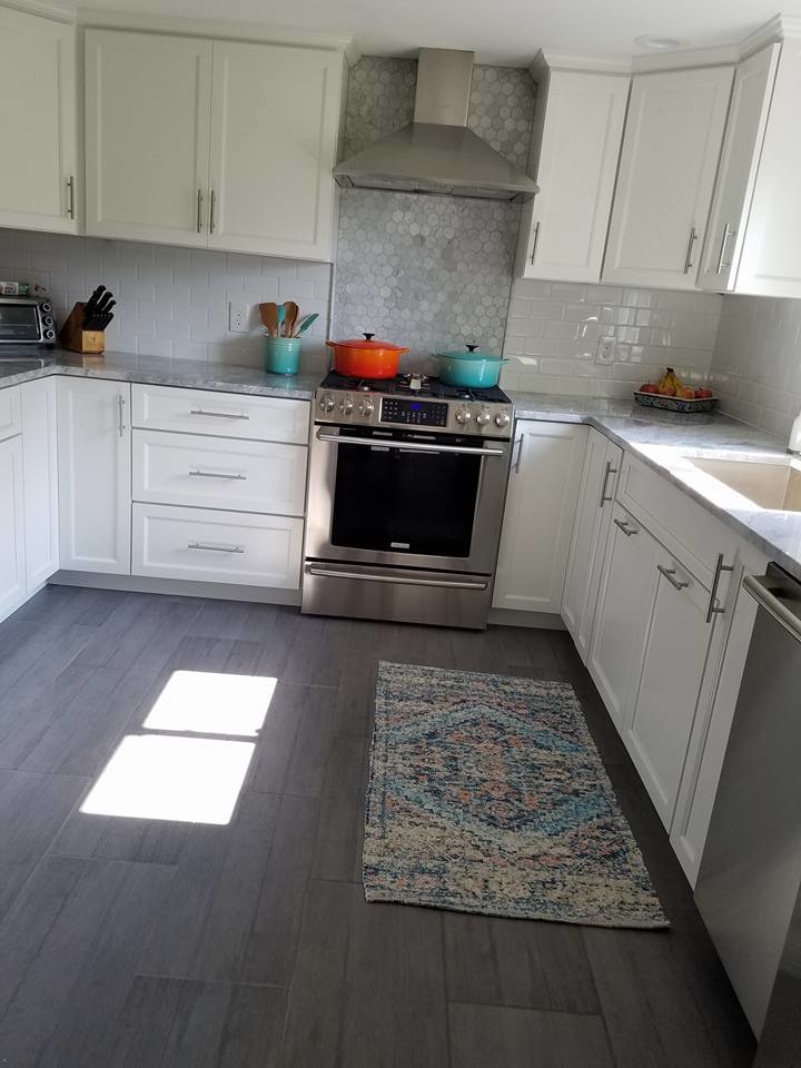 Mid-sized transitional u-shaped dark wood floor and brown floor eat-in kitchen photo in Providence with an undermount sink, recessed-panel cabinets, white cabinets, granite countertops, white backsplash, subway tile backsplash, stainless steel appliances, a peninsula and gray countertops