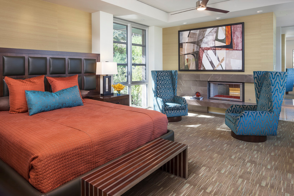 Example of a mid-sized trendy master carpeted bedroom design in Los Angeles with beige walls and a two-sided fireplace