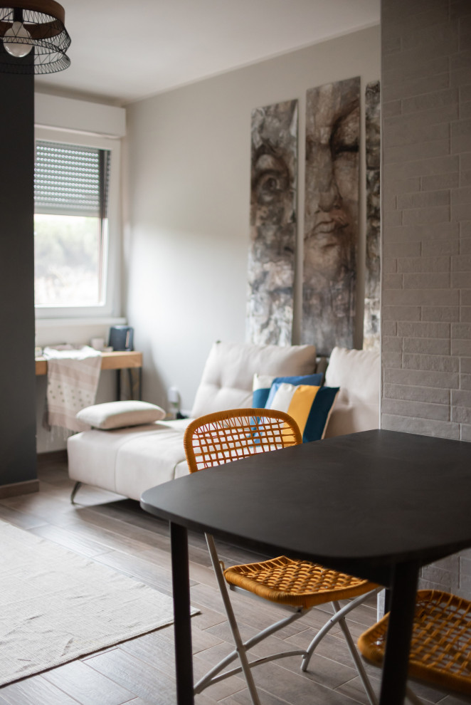 Kleines, Abgetrenntes Industrial Wohnzimmer mit grauer Wandfarbe, Porzellan-Bodenfliesen und braunem Boden in Rom