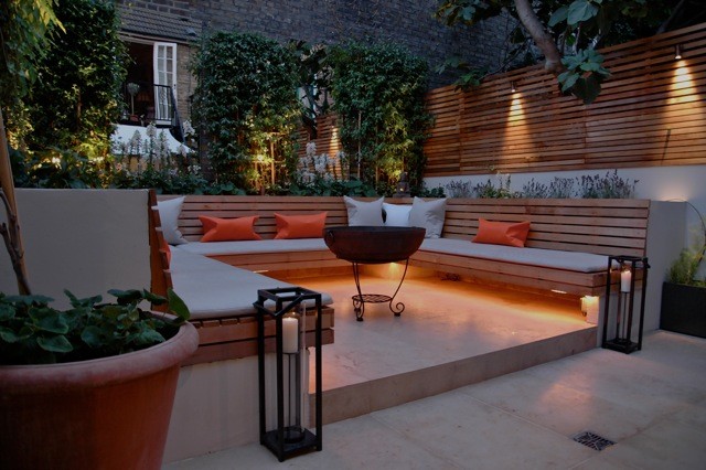 Inspiration for a small contemporary backyard shaded garden for summer in London with a retaining wall and concrete pavers.