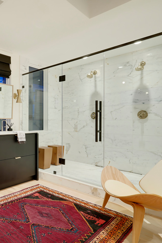 This is an example of a mid-sized eclectic master bathroom in Calgary with flat-panel cabinets, black cabinets, a freestanding tub, a double shower, white tile, stone tile, white walls, light hardwood floors, an undermount sink, quartzite benchtops, brown floor, a hinged shower door, white benchtops, a double vanity and a built-in vanity.