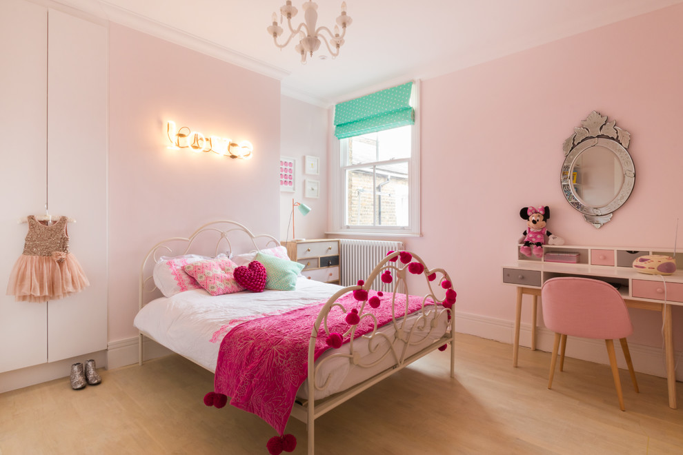 Transitional kids' bedroom in London with pink walls and light hardwood floors for kids 4-10 years old and girls.