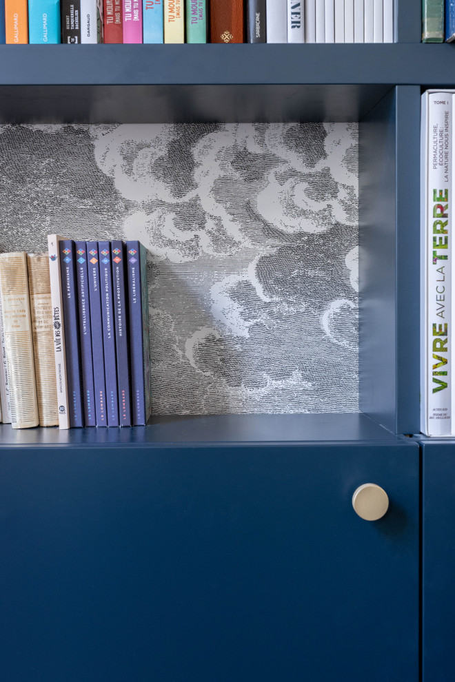 Idée de décoration pour un grand salon design fermé et haussmannien avec une bibliothèque ou un coin lecture, un mur blanc, parquet clair et une cheminée standard.