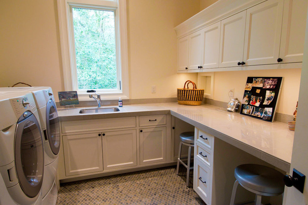 This is an example of a traditional u-shaped laundry room in Portland with a side-by-side washer and dryer.
