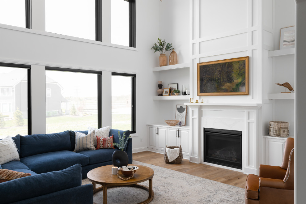 Example of a large classic open concept light wood floor, vaulted ceiling and wainscoting living room design in Detroit with white walls, a standard fireplace, a wood fireplace surround and a wall-mounted tv