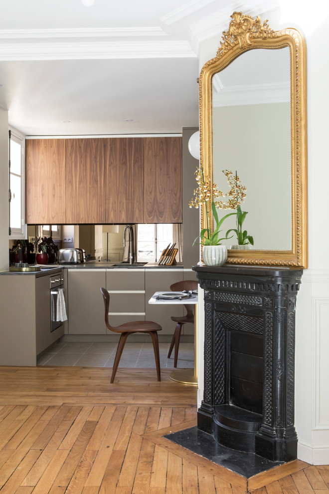 Inspiration for a small contemporary l-shaped open plan kitchen in Paris with an undermount sink, beaded inset cabinets, green cabinets, beige splashback, mirror splashback, panelled appliances, ceramic floors, no island, brown floor and grey benchtop.