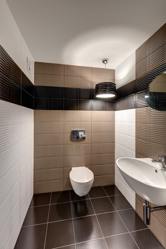 This is an example of a mid-sized contemporary powder room in Yekaterinburg with a wall-mount toilet, multi-coloured tile, ceramic tile, multi-coloured walls, ceramic floors, a wall-mount sink and brown floor.