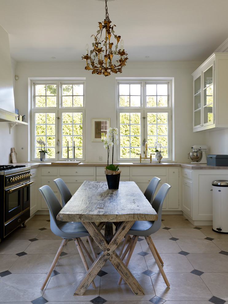 Design ideas for a small traditional separate kitchen in Copenhagen with a drop-in sink, raised-panel cabinets, white cabinets, wood benchtops, white splashback, coloured appliances and limestone floors.