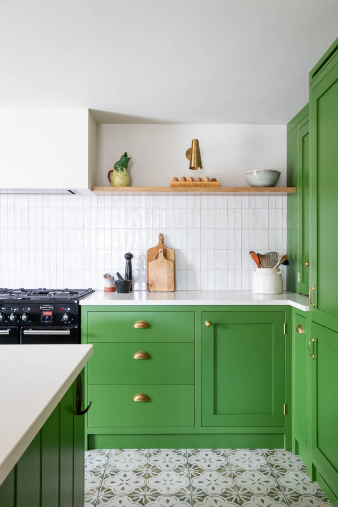 Modern inredning av ett mellanstort vit vitt kök, med en rustik diskho, skåp i shakerstil, gröna skåp, bänkskiva i kvartsit, vitt stänkskydd, stänkskydd i keramik, svarta vitvaror, klinkergolv i porslin, en köksö och flerfärgat golv