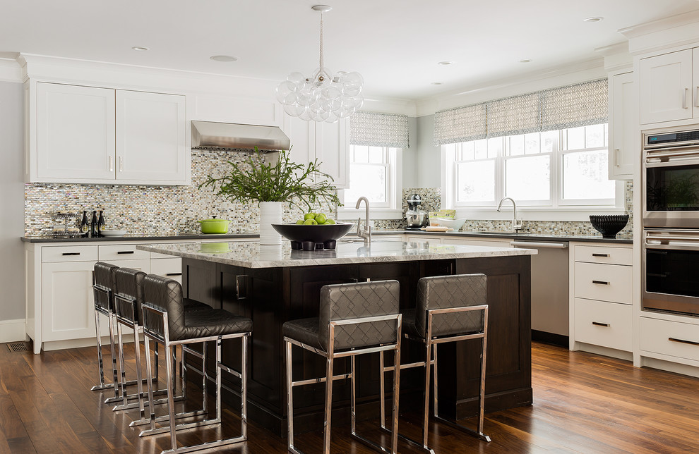 Design ideas for a large transitional l-shaped open plan kitchen in Boston with shaker cabinets, white cabinets, metallic splashback, mosaic tile splashback, stainless steel appliances, medium hardwood floors, with island, an undermount sink, granite benchtops and brown floor.