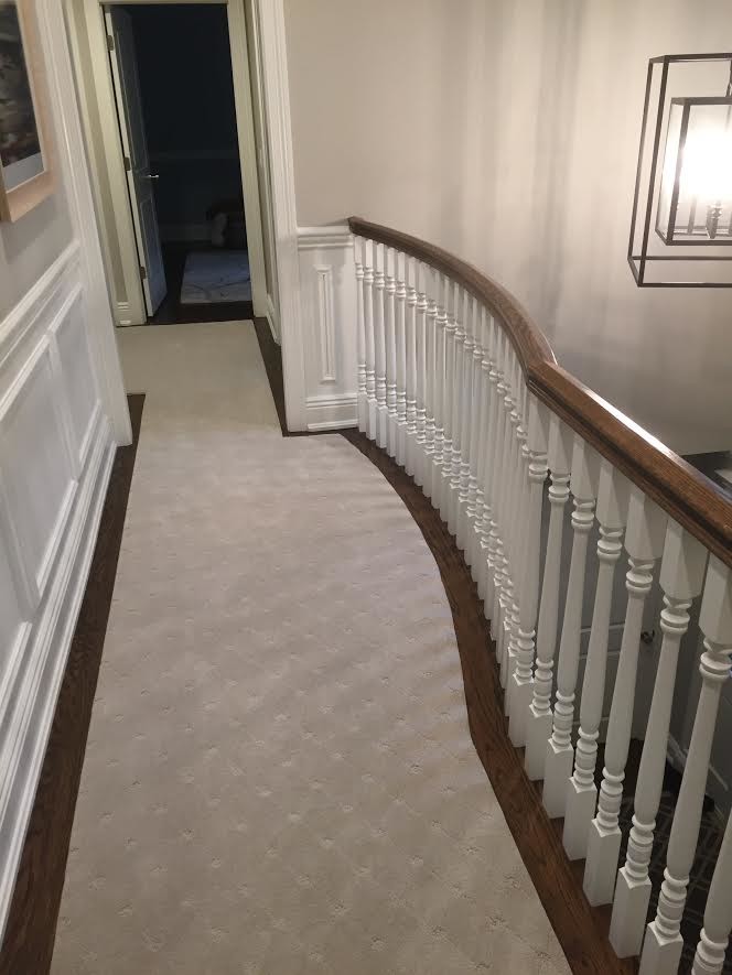Photo of a mid-sized transitional hallway in New York with beige walls and carpet.