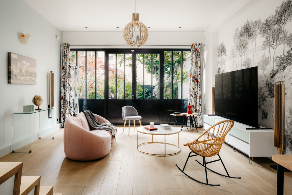 Modernes Wohnzimmer mit weißer Wandfarbe, hellem Holzboden, freistehendem TV, beigem Boden und Tapetenwänden in Paris