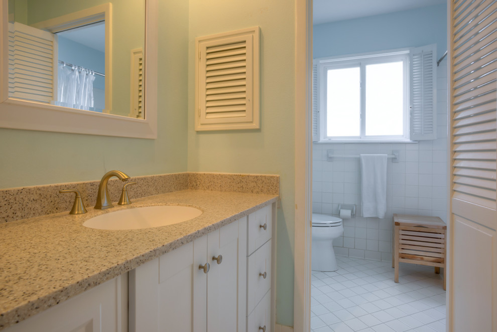 Mid-sized contemporary bathroom in Austin with shaker cabinets, white cabinets, a one-piece toilet, blue walls, engineered quartz benchtops, porcelain floors and an undermount sink.