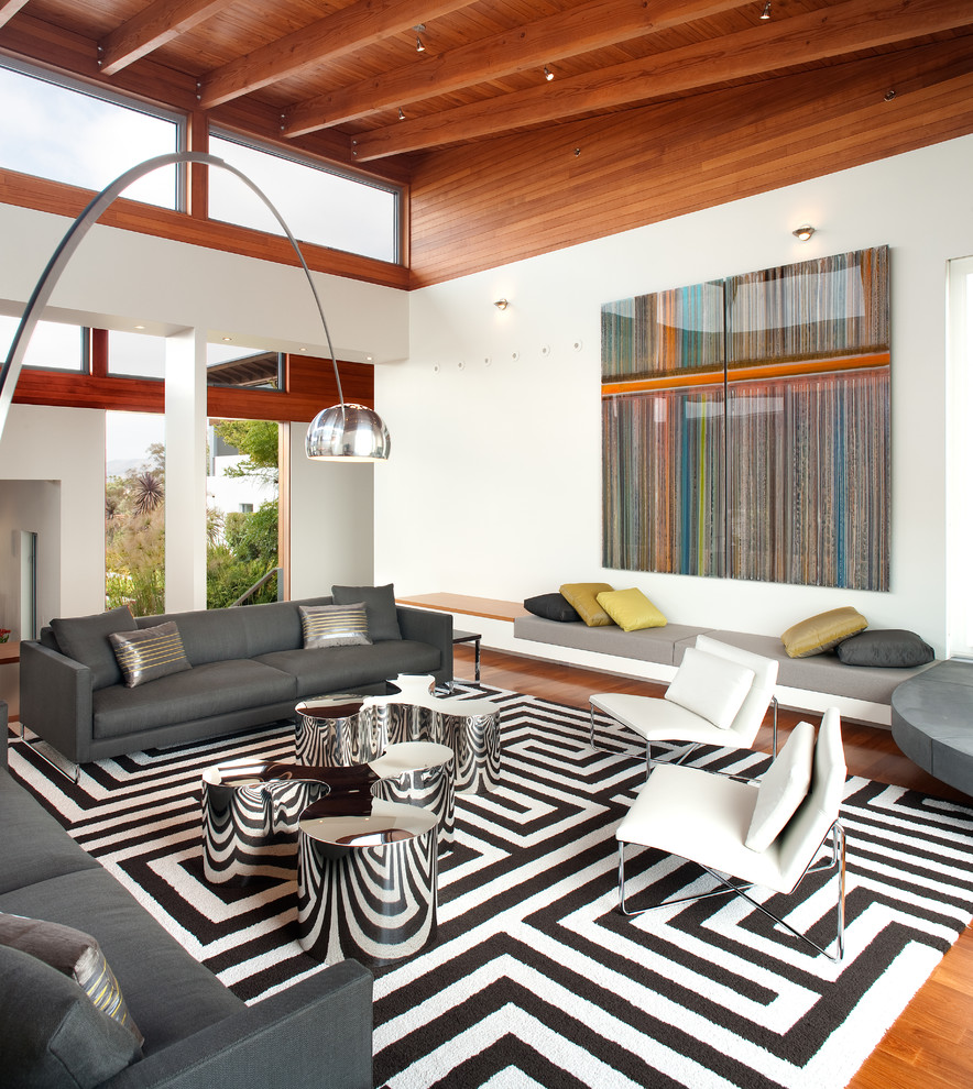 This is an example of a contemporary living room in San Diego with white walls, medium hardwood floors and brown floor.