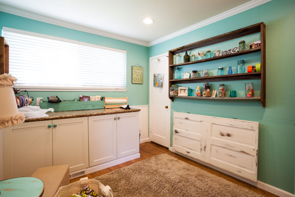 Inspiration for a mid-sized beach style craft room in San Francisco with medium hardwood floors, a built-in desk and blue walls.