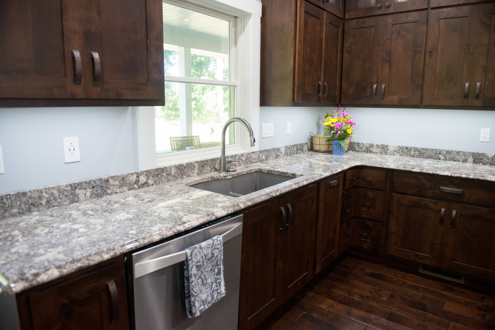 Example of a transitional l-shaped open concept kitchen design with an undermount sink, shaker cabinets, dark wood cabinets, granite countertops, stainless steel appliances, an island and multicolored countertops