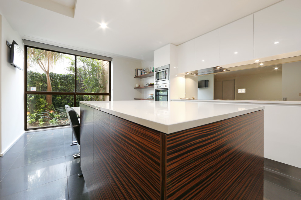 Inspiration for a mid-sized contemporary galley eat-in kitchen in Melbourne with an undermount sink, flat-panel cabinets, white cabinets, quartz benchtops, metallic splashback, mirror splashback, stainless steel appliances, porcelain floors and with island.