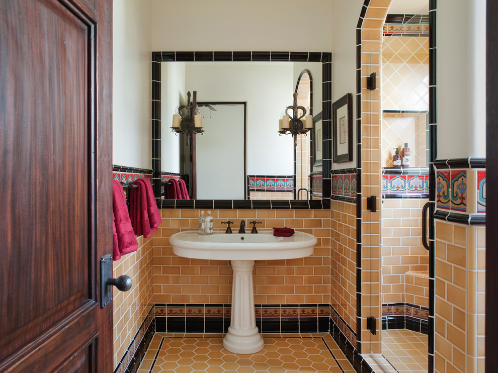 This is an example of a mediterranean bathroom in San Francisco with a pedestal sink, white walls and orange tile.