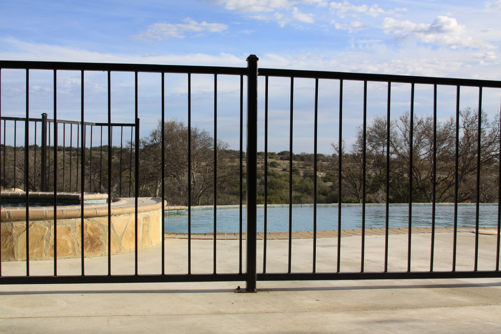 Mountain style backyard stamped concrete and custom-shaped natural hot tub photo in Austin