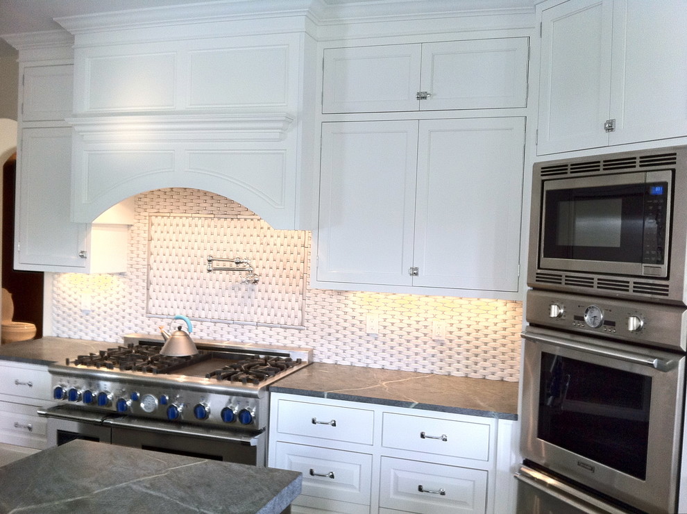 Open concept kitchen - large transitional u-shaped dark wood floor and brown floor open concept kitchen idea in Miami with a farmhouse sink, shaker cabinets, white cabinets, granite countertops, multicolored backsplash, stone tile backsplash, stainless steel appliances and an island