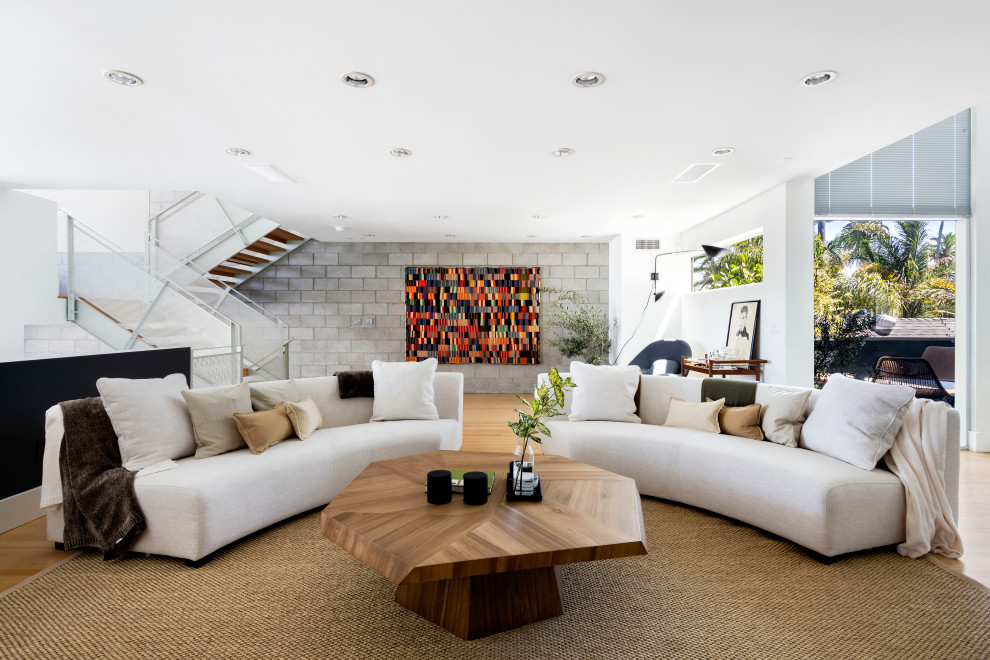 This is an example of a mid-sized modern formal open concept living room in Los Angeles with white walls, light hardwood floors and beige floor.