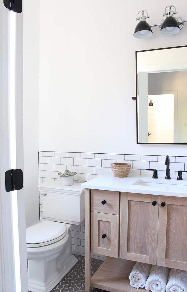 Inspiration for a contemporary bathroom in San Francisco with a freestanding tub, white tile, white walls, porcelain floors, an undermount sink, quartzite benchtops, grey floor, black benchtops, recessed-panel cabinets, light wood cabinets and subway tile.