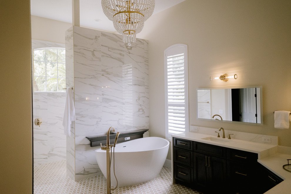 This is an example of a large transitional master bathroom in Orlando with beaded inset cabinets, dark wood cabinets, a freestanding tub, an open shower, a one-piece toilet, white tile, marble, white walls, mosaic tile floors, a drop-in sink, engineered quartz benchtops, brown floor, an open shower, white benchtops, a shower seat, a double vanity and a built-in vanity.