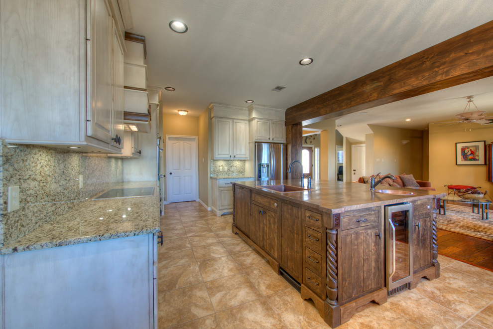 Example of a mid-sized mountain style l-shaped eat-in kitchen design in Austin with a single-bowl sink, wood countertops, stainless steel appliances and an island